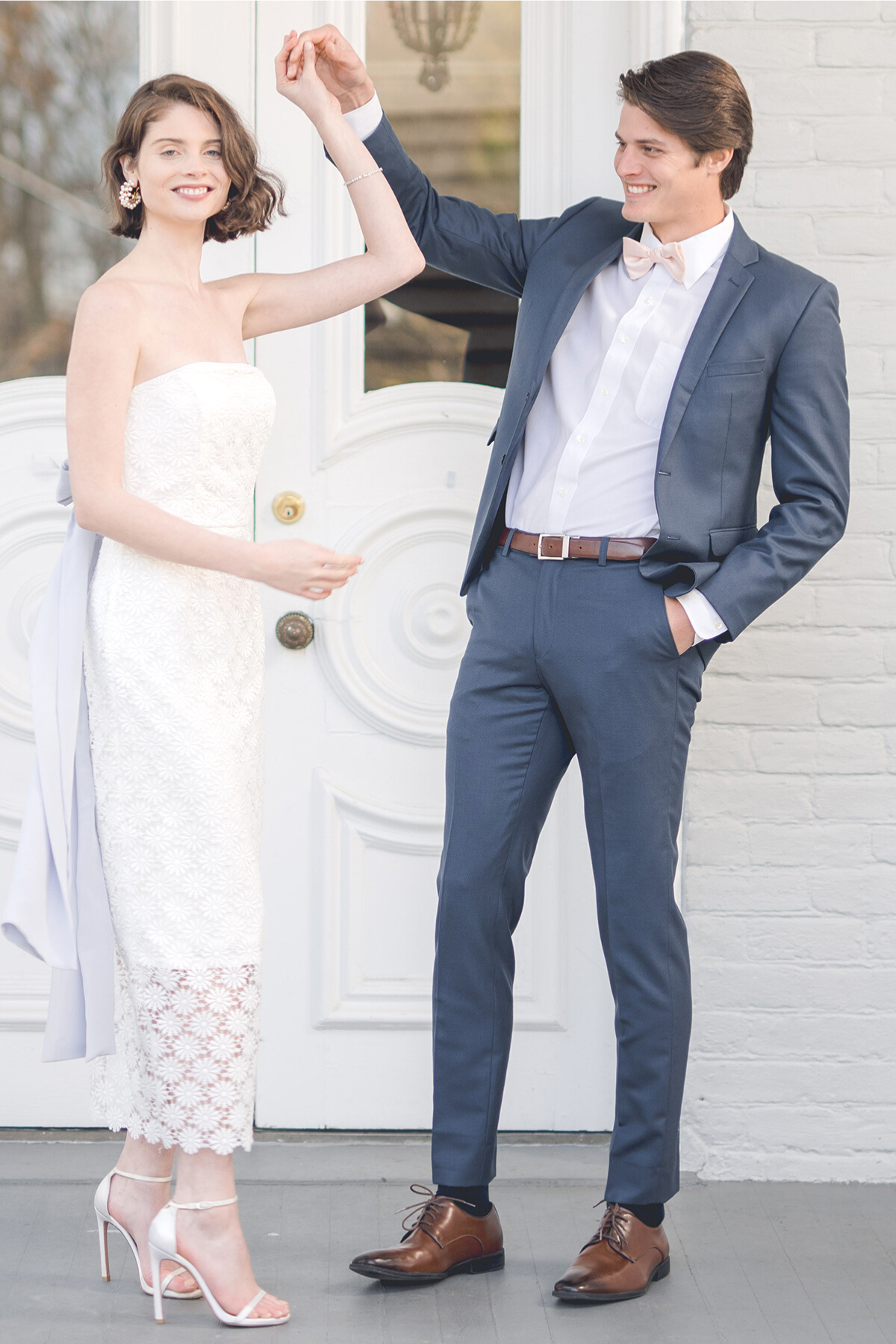 bride wearing simple lace wedding dress and midi strapless white rehearsal dinner dress dancing with groom