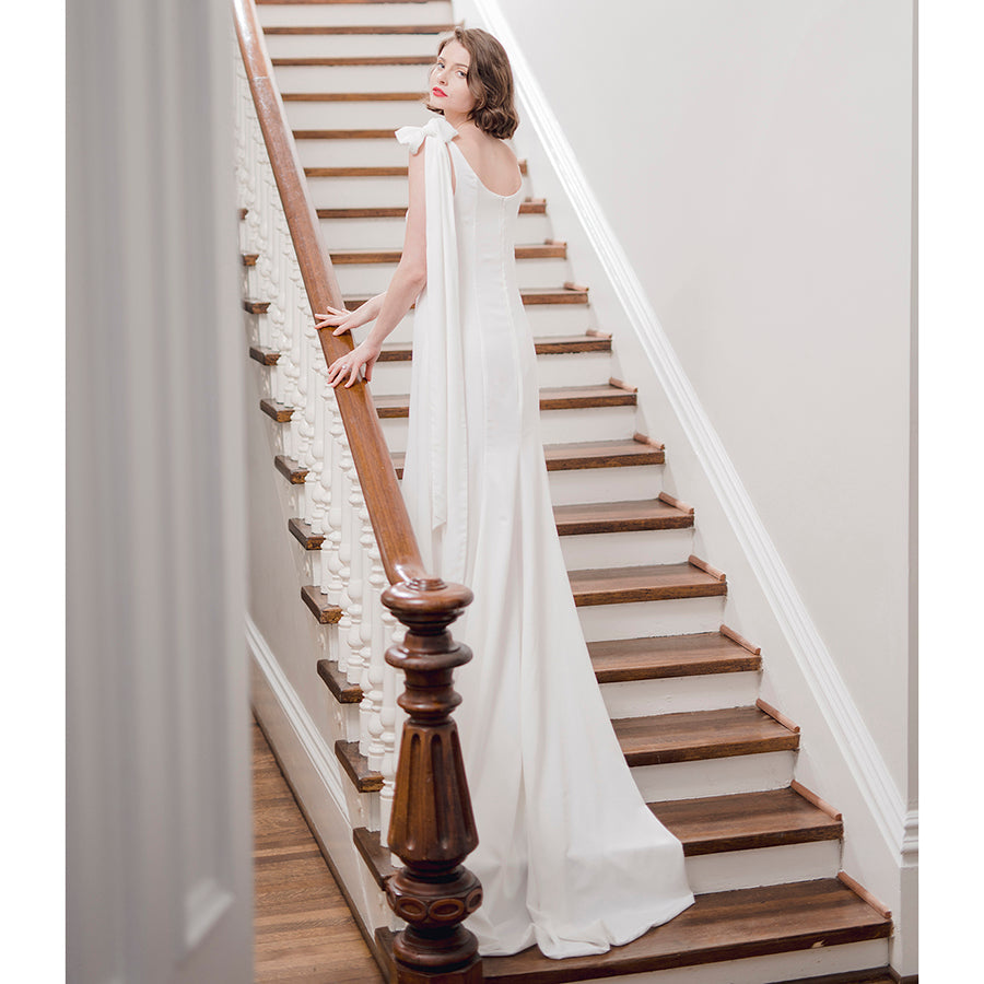 Beautiful bride in minimalist designer white wedding gown reminiscient of the style worn by and made popular by Carolyn Bisette Kennedy