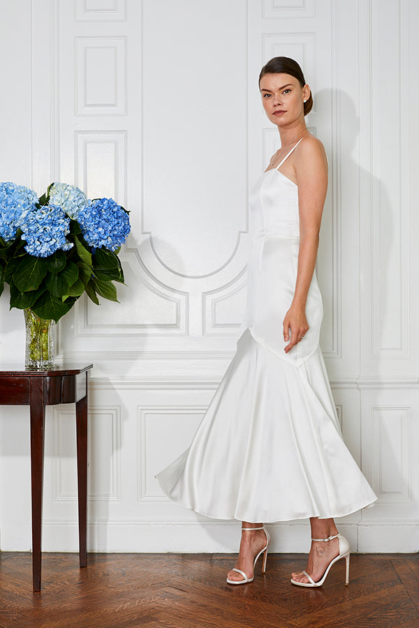 white rehearsal dinner dress and tea length civil wedding dress with blue flowers on a table