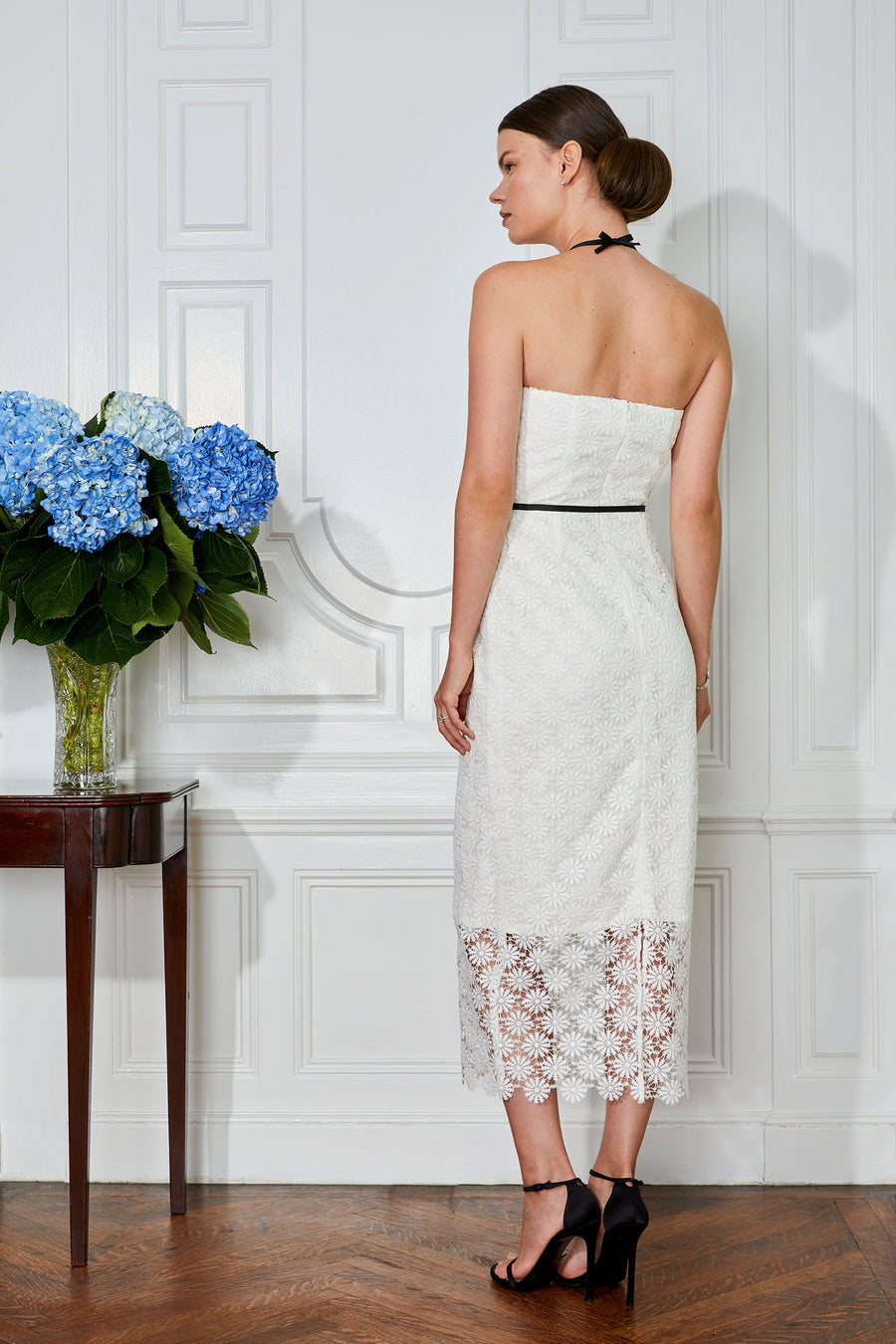 Stylish bride in elegant white lace strapless midi sheath rehearsal dinner dress and modern bridal shower dress
