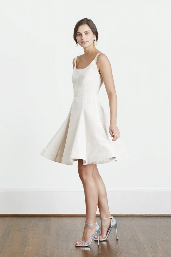 Bride twirling in backless short white rehearsal dinner dress and engagement party dress 