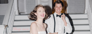 Happy bride and groom leaving the reception wearing strapless white tea length midi tulle princess wedding reception dress