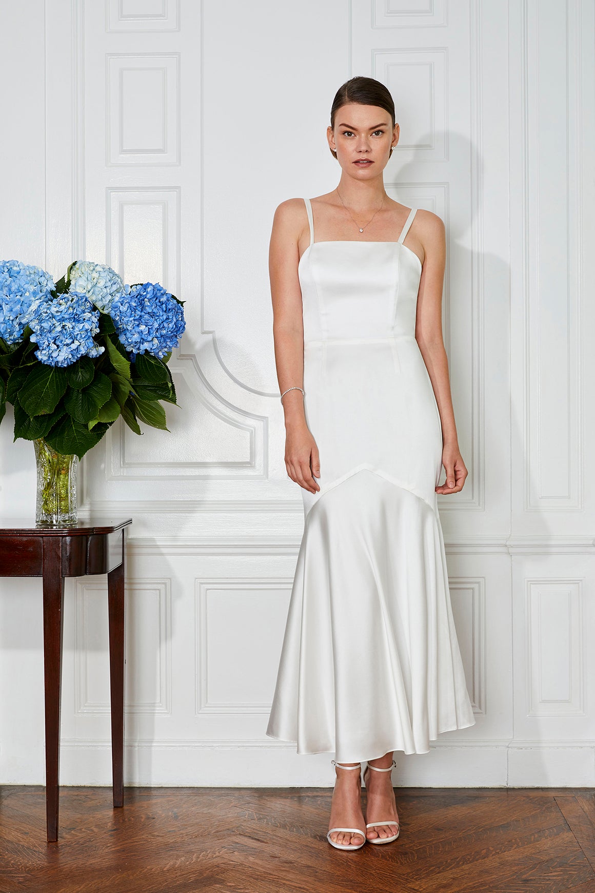 white rehearsal dinner dress and tea length civil wedding dress with blue flowers on a table