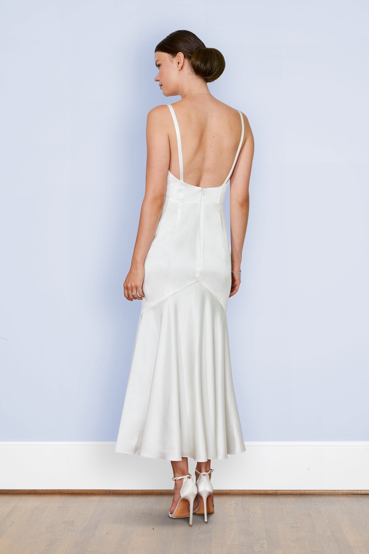 Back view of bride wearing backless bias off white rehearsal dinner dress & mermaid wedding dress