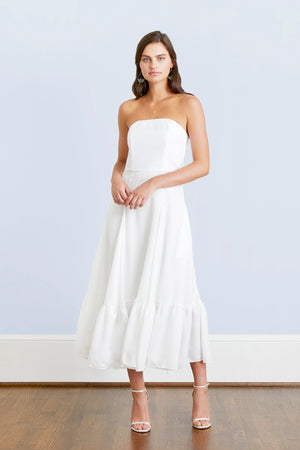 Bride wearing casual strapless white tea length wedding dress to a destination rustic romantic venue beach wedding 