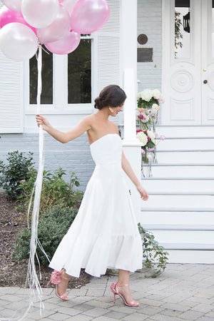 Bride wearing flirty boho chic simple white strapless tea length wedding dress to outdoor rehearsal dinner reception
